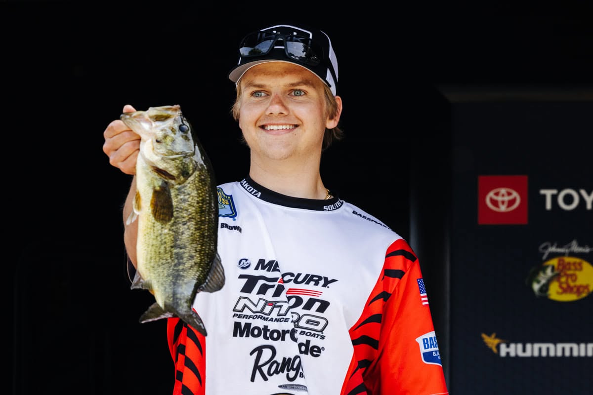 Young angler holding up a smallmouth bass at a tournament weigh-in