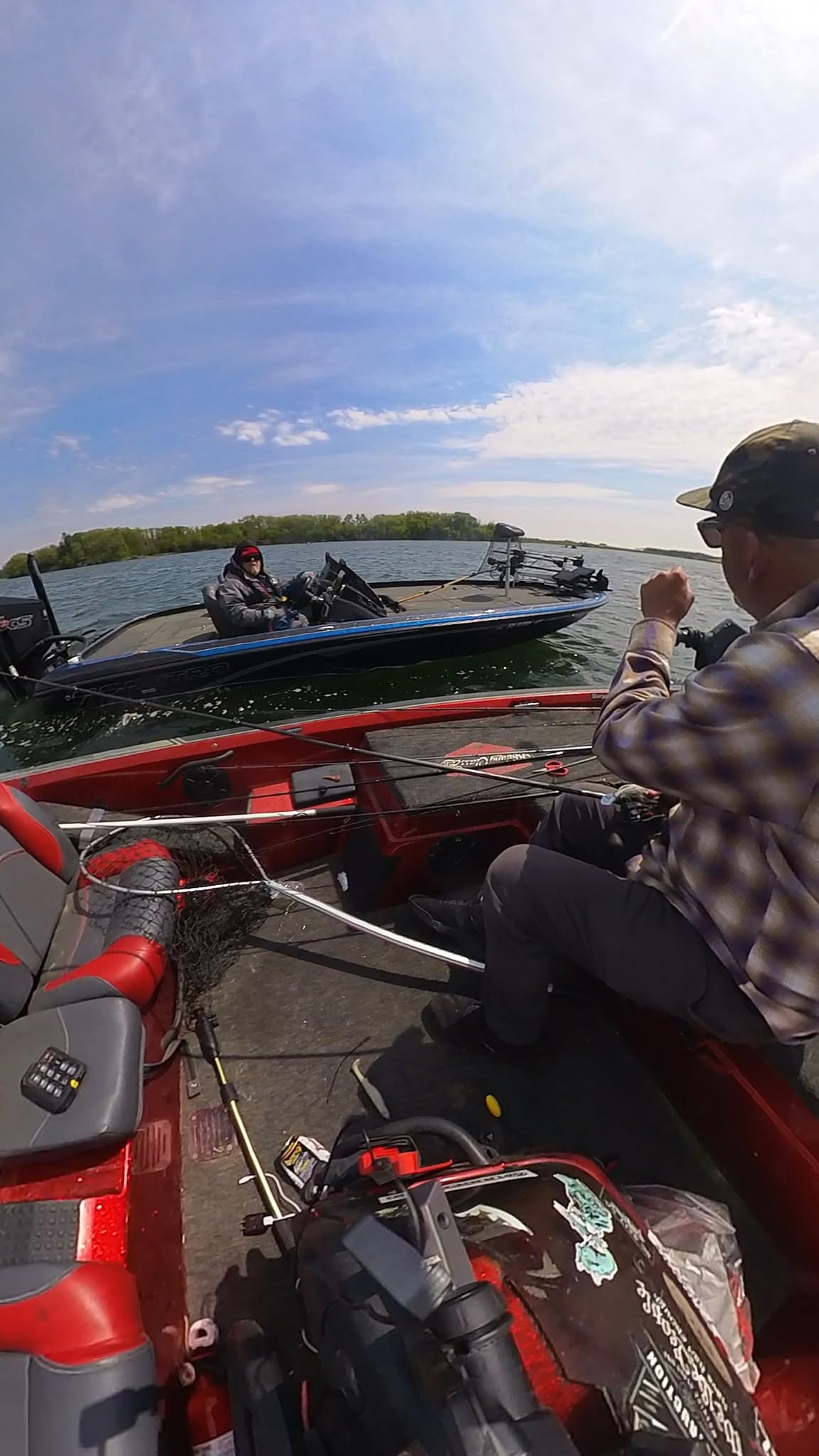 Two bass boats on a sunny lake seen from the water