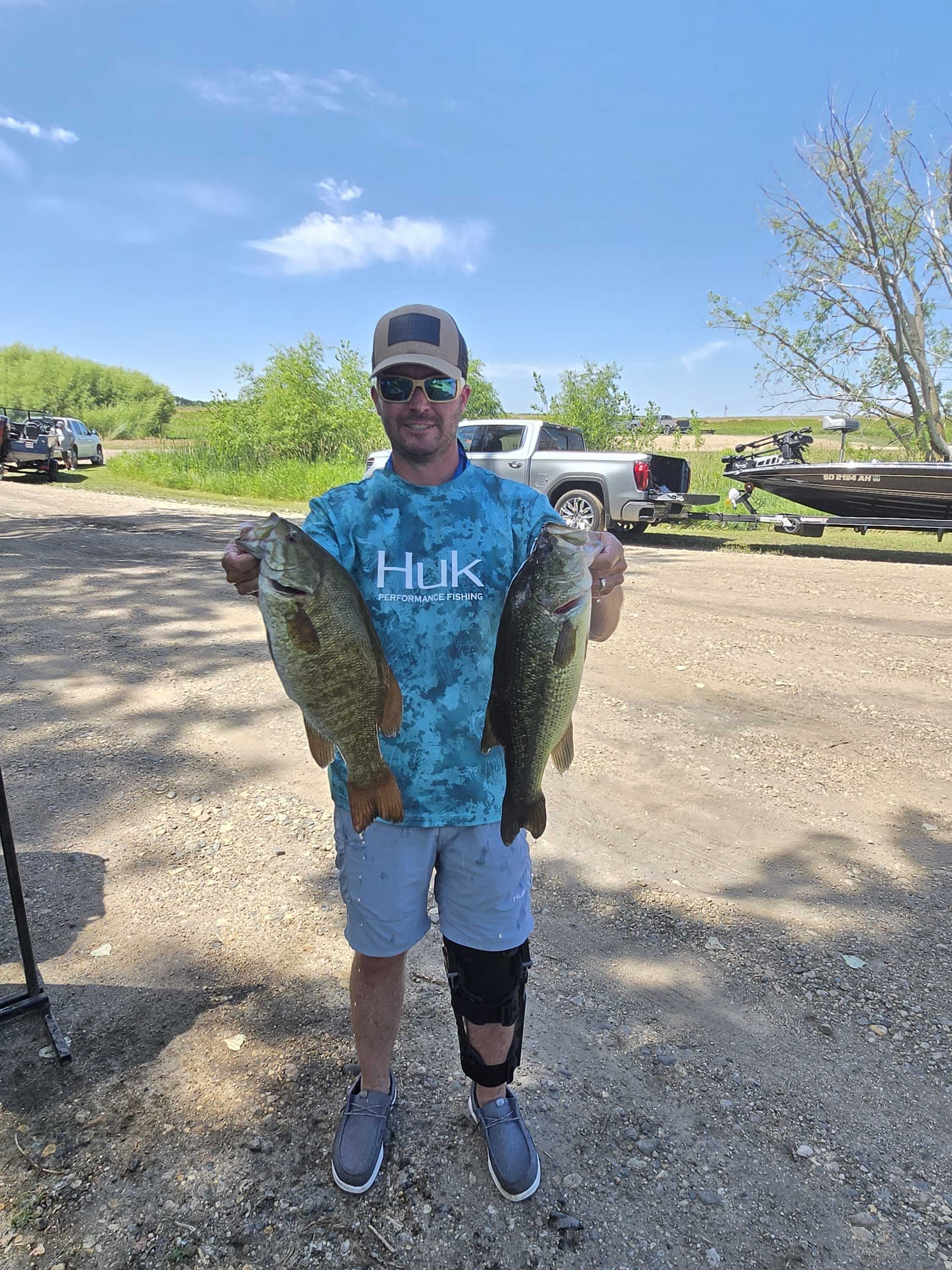 Angler holding a smallmouth and a largemouth bass at the Blue Dog ramp